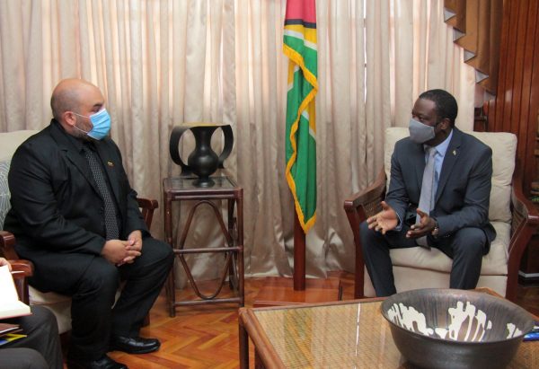 Minister Hugh Todd seated on the right and on the left Moses Chavez, Chargé d' Affaires, Embassy of the Bolivarian Republic of Venezuela.