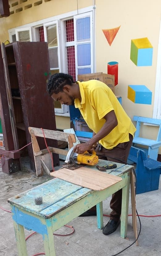 Teacher building furniture and creating prayer space for his students